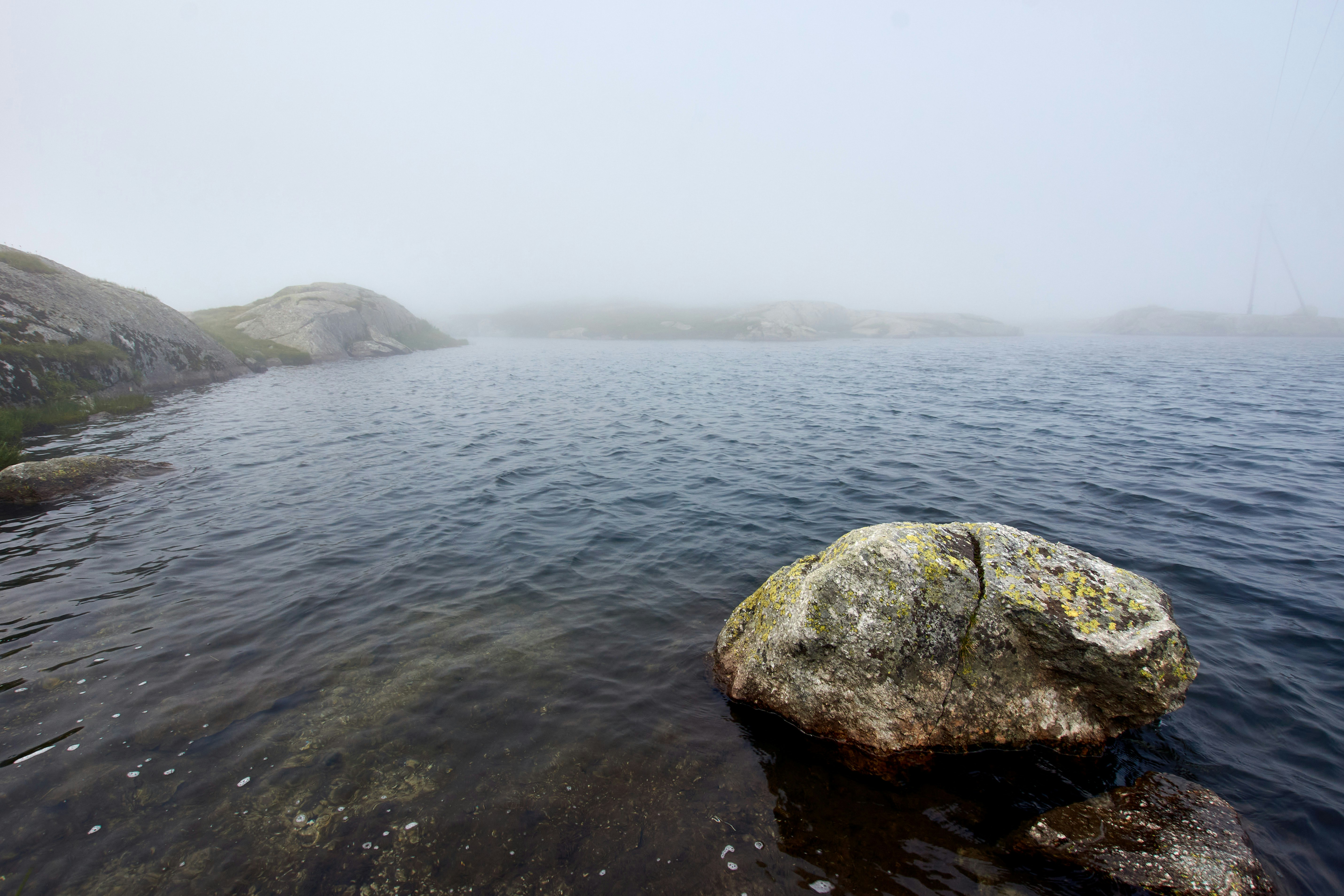 gray rock on body of water during daytime